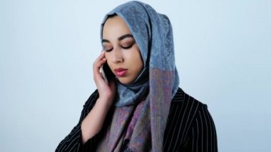 genç güzel arap kadın numara arama ve izole beyaz arka plan üzerinde akıllı telefondan birini arayan
