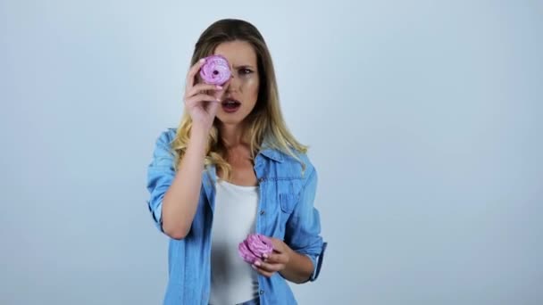 Izole beyaz arka plan üzerinde lezzetli bir cupcake ile gözünü kapatarak etrafında aptal genç güzel kadın grimacing — Stok video