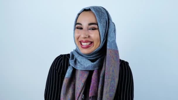 Junge schöne arabische Frau lacht großzügig und zeigt ihre weißen Zähne auf isoliertem weißem Hintergrund — Stockvideo