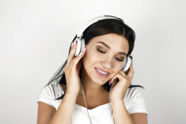 izole beyaz arka plan memnun duygu kulaklık en sevdiği müzik dinlerken esmer genç kadın
