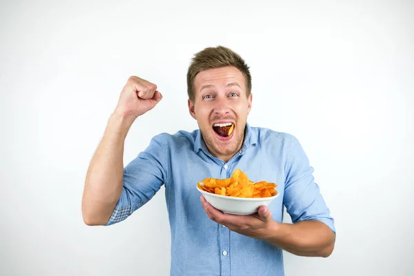 Ung stilig man äter paprika chips håller knytnäve upp på isolerad vit bakgrund — Stockfoto