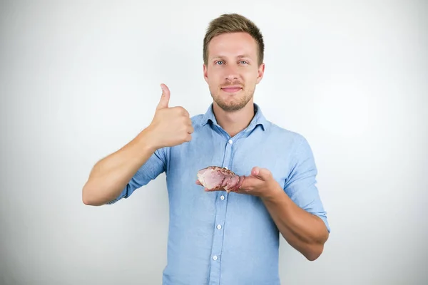 Jovem homem bonito segurando bacon fatiado mostrando como sinal no fundo branco isolado — Fotografia de Stock