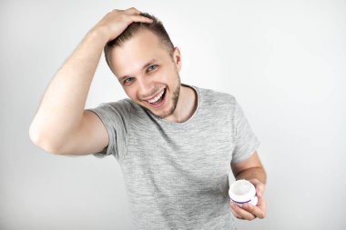 izole beyaz arka plan üzerinde saçlarına balmumu uygulayan genç yakışıklı adam