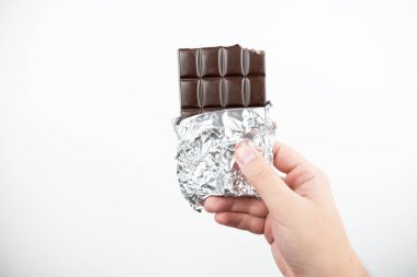 izole beyaz arka plan üzerinde çikolata çubuğu tutan el görüntü