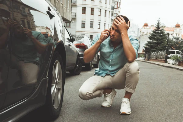 Giovane bell'uomo sembra nervoso auto rotto in mezzo alla strada chiamando alla stazione di servizio — Foto Stock