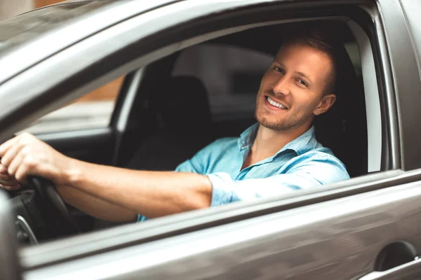 Giovane bell'uomo sorridente guida auto da vicino — Foto Stock