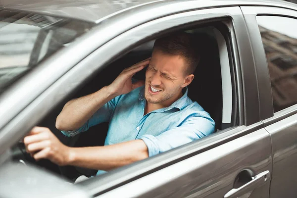 Giovane bell'uomo che soffre di mal di testa mentre guida in macchina — Foto Stock