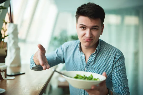 Joven guapo hombre no está satisfecho con la ensalada que muestra a camarero sintiéndose decepcionado — Foto de Stock