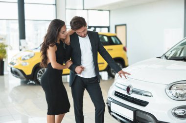 güzel genç çift erkek ve kadın bayilik merkezinde yeni bir araba arıyor