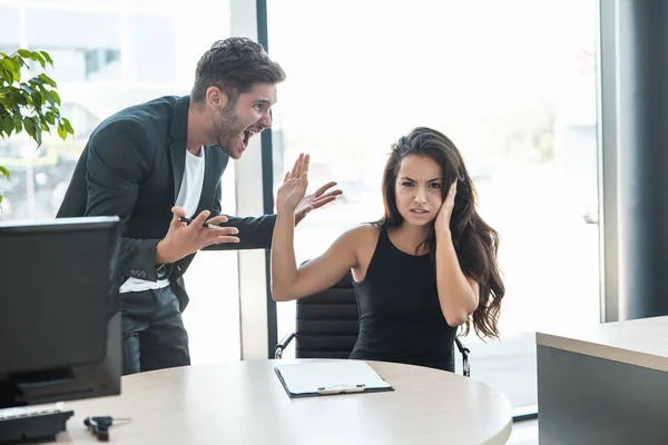 Estricto jefe hombre jurando en molesto cansado empleado mujer para el mal trabajo en el lugar de trabajo buscando enojado —  Fotos de Stock
