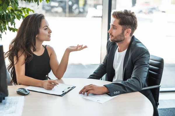 Vacker ung kvinna Manager hjälpa henne stilig man klient under Köp affär på kontoret — Stockfoto