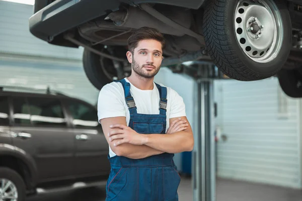 Joven mecánico guapo que trabaja en el departamento de servicio de coches — Foto de Stock