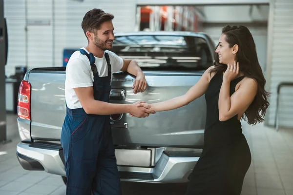 Joven mecánico guapo y hermosa mujer cliente estrechando la mano en gratitud por el gran servicio — Foto de Stock