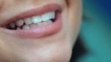 Beyaz, mükemmel dişleri olan kadın yakından gülümsüyor.