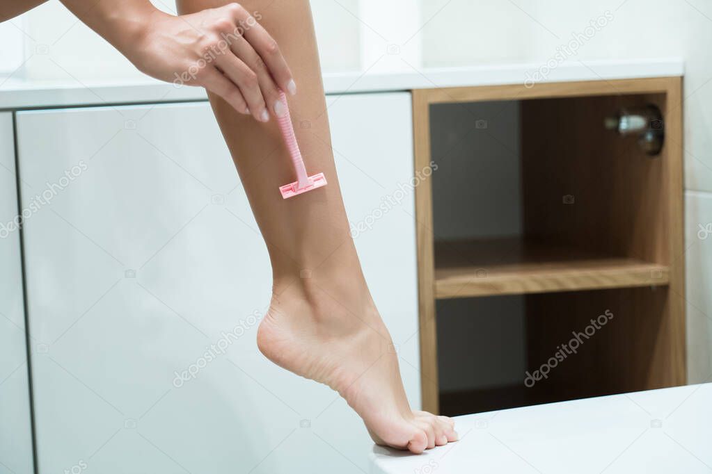 woman having her leg in bright bathroom