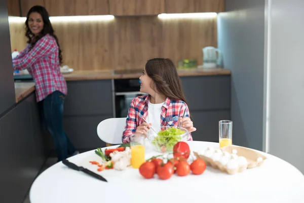 Ung vacker kvinna diska och hennes söta dotter hjälper till att laga frukost i köket ser glad — Stockfoto