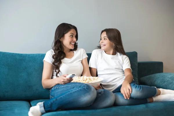 Belle jeune mère avec son mignon adolescent fille regarder film sur le canapé manger pop-corn — Photo