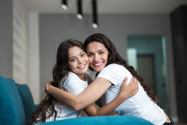 Bella giovane madre e la sua graziosa figlia adolescente che si abbracciano sentendosi amore e felicità — Foto Stock