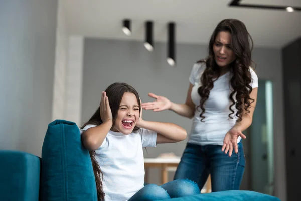Jong mooi vrouw hebben een ruzie met haar tiener dochter in de woonkamer — Stockfoto