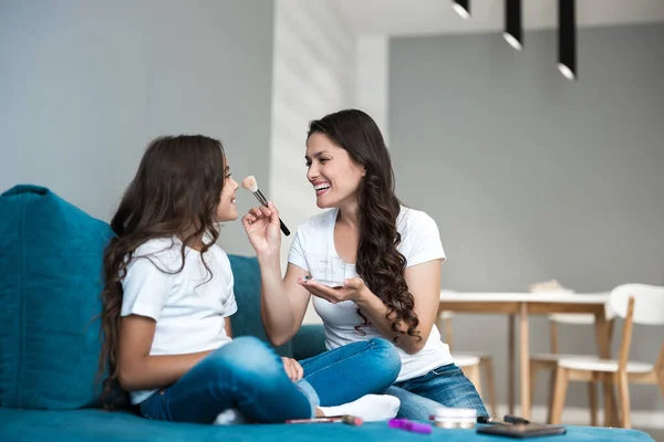 Belle jeune mère avec sa fille adolescente mignonne ayant journée beauté faisant maquillage appliquant poudre regardant heureux — Photo