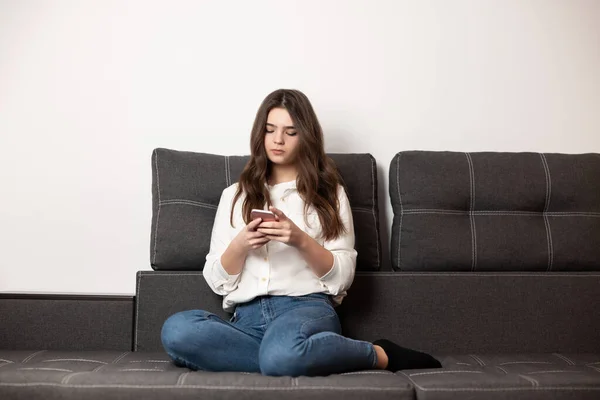 Tineri Frumos Bruneta Femeie Mesaj Text Smartphone Stând Canapea Apartamentul — Fotografie, imagine de stoc