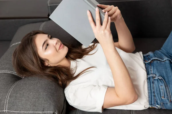 Young Beautiful Brunette Woman Reading Book While Lying Sofa Her — Stock Photo, Image