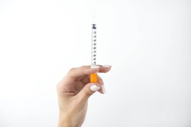 Kadının elleri, izole edilmiş beyaz arka plan, sağlık ve tıbbi konsept üzerinde elinde şırınga tutuyordu..