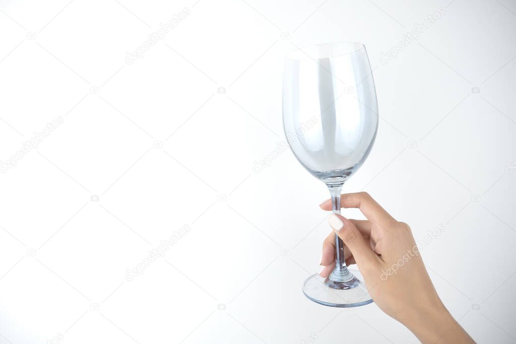 image of woman's hands holding empty glass of wine on isolated white background.