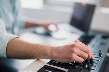 Genç adamın elleri klavye piyanosu çalıyor, müzik besteliyor, müzik kaydı, konsepti, sanat, şarkı kompozisyonu .