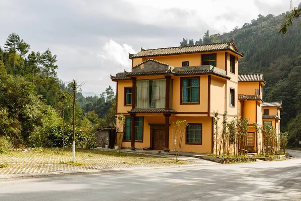Триповерховий житловий будинок біля дороги в горах — стокове фото