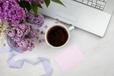 Çiçek kompozisyon fincan kahve ile güzel Mor Lila Beyaz ahşap zemin üzerinde yapılmış. Kadınsı ofis masası