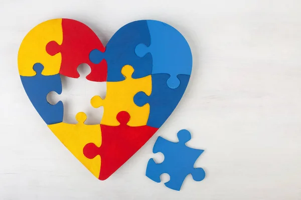 Un cuore colorato fatto di pezzi simbolici di puzzle autistico. — Foto Stock