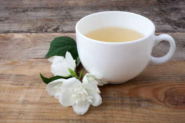 Glas Tee mit Jasminblüten auf Holzgrund. — Stockfoto