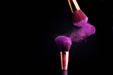Makyaj fırça ile renkli toz patlama siyah arka plan üzerine su sıçramalarına
