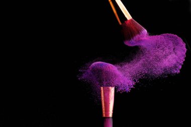 Makyaj fırça ile renkli toz patlama siyah arka plan üzerine su sıçramalarına