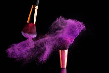 Makyaj fırça ile renkli toz patlama siyah arka plan üzerine su sıçramalarına