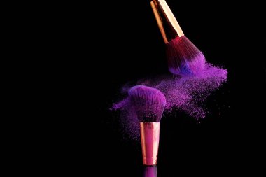 Makyaj fırça ile renkli toz patlama siyah arka plan üzerine su sıçramalarına