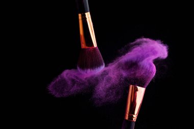 Makyaj fırça ile renkli toz patlama siyah arka plan üzerine su sıçramalarına