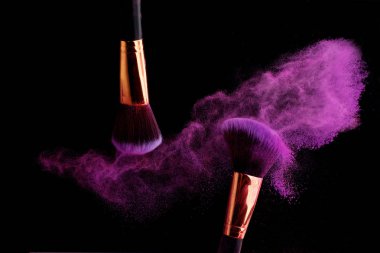 Makyaj fırça ile renkli toz patlama siyah arka plan üzerine su sıçramalarına