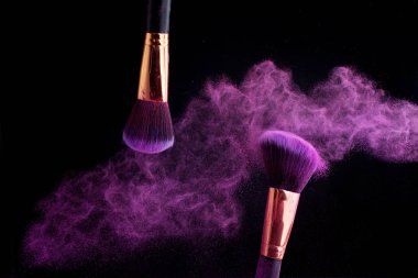 Makyaj fırça ile renkli toz patlama siyah arka plan üzerine su sıçramalarına