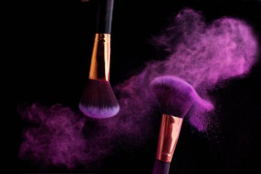 Makyaj fırça ile renkli toz patlama siyah arka plan üzerine su sıçramalarına