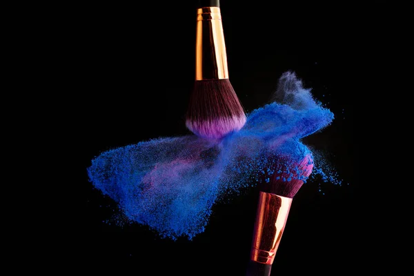 Make-up borstel met kleurrijke poeder spatten explosie op zwarte achtergrond — Stockfoto