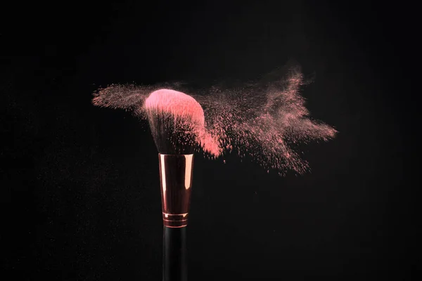 Make-up borstel met kleurrijke poeder spatten explosie op zwarte achtergrond — Stockfoto