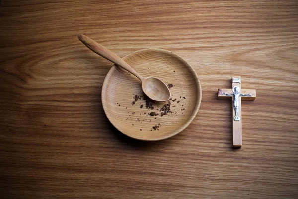 Fasting, Lent. Plate and cross on wooden backgroud. — Stock Photo, Image