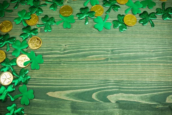 St Patricks Day hörnet gränsa av shamrocks och guldmynt på grön trä bakgrund — Stockfoto