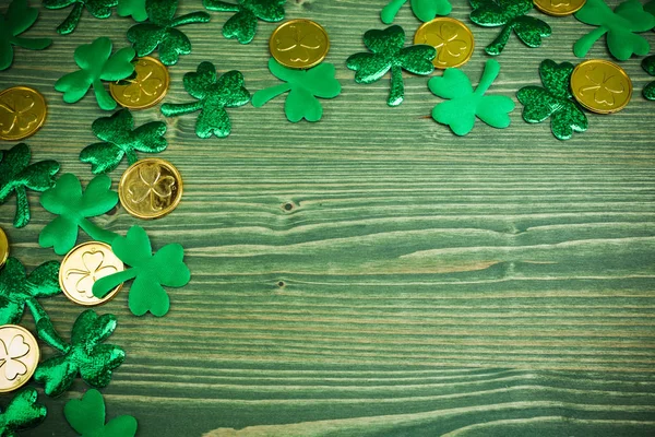 St patricks day corner border von Shamrocks und Goldmünzen auf grünem Holz Hintergrund — Stockfoto