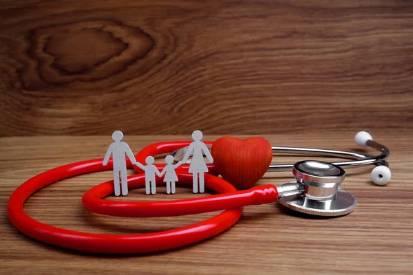 Concepto de Seguro Médico. Recorte familiar y estetoscopio sobre fondo de madera —  Fotos de Stock