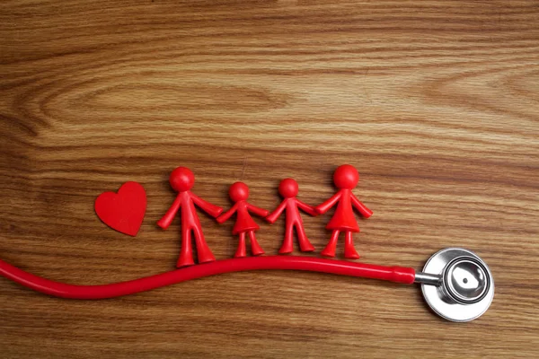 Stetoskop och familjen dockan med hjärtat. Begreppet hälsa. — Stockfoto