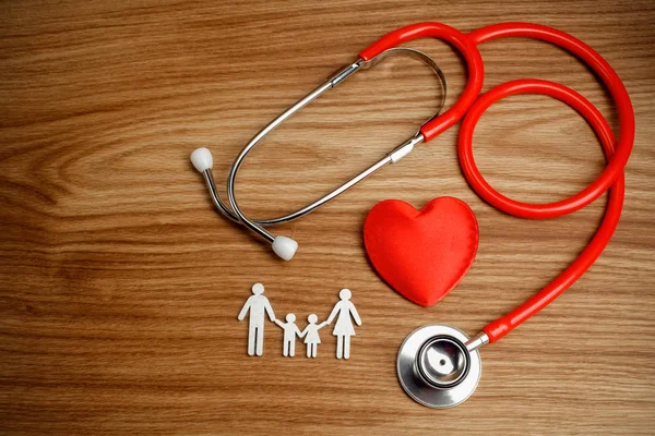 Medicinsk försäkring koncept. Familjen cutout och stetoskop på trä bakgrund — Stockfoto