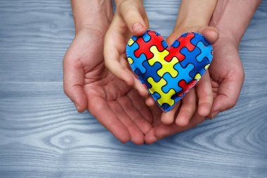 Dünya otizm farkındalık günü, bulmaca veya Yapboz desen kalp otistik childs ve babası el ile